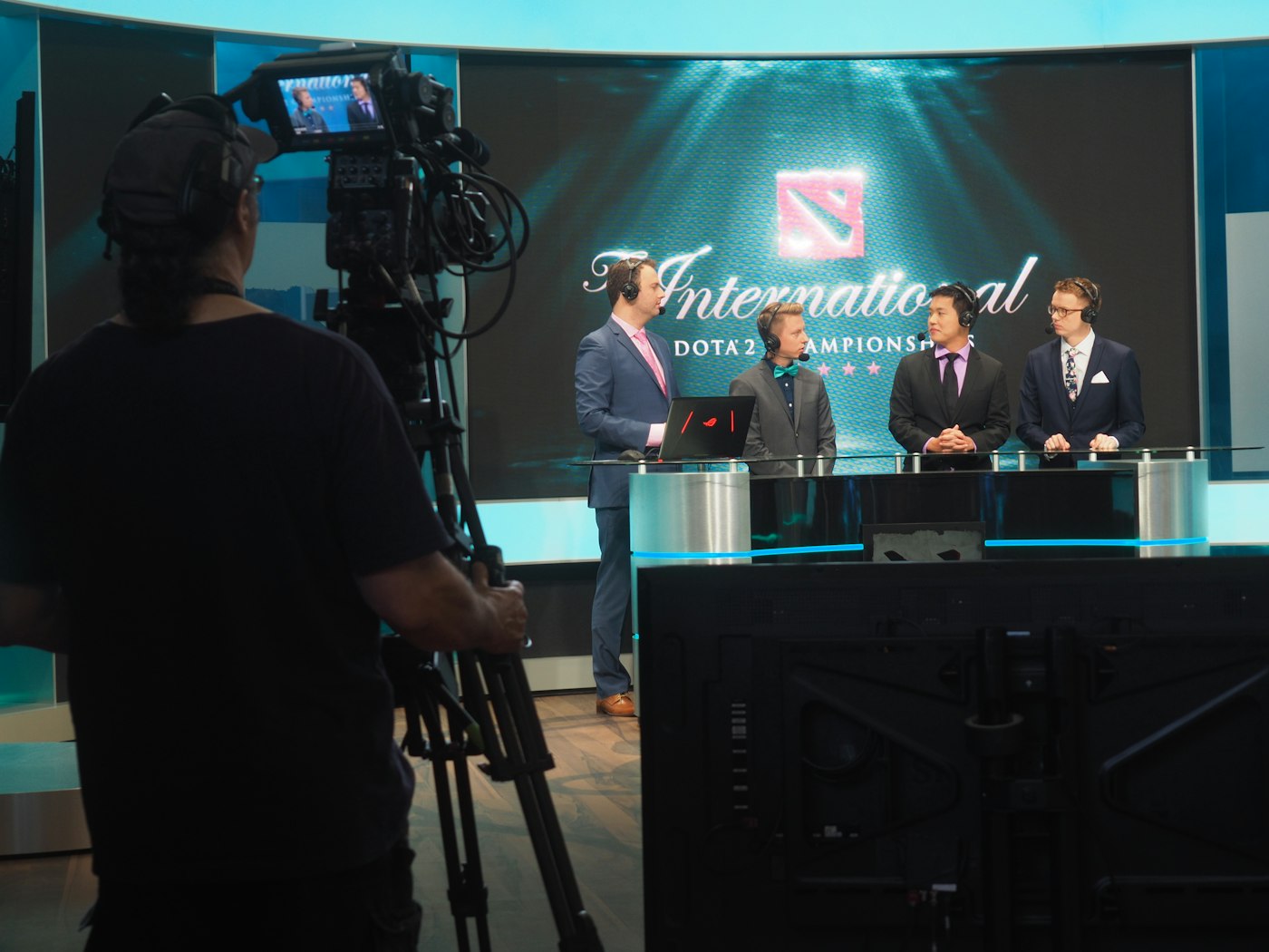 A camera operator filming a panel in a studio